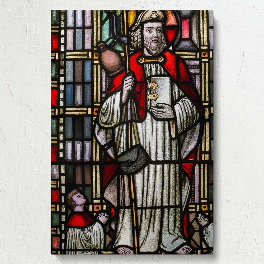 Sacred stained glass artwork depicting a saint with a staff and book, dressed in red and white robes, featuring a halo of light, and accompanied by a kneeling figure in prayer, set within intricate stained glass designs and Gothic geometric patterns.