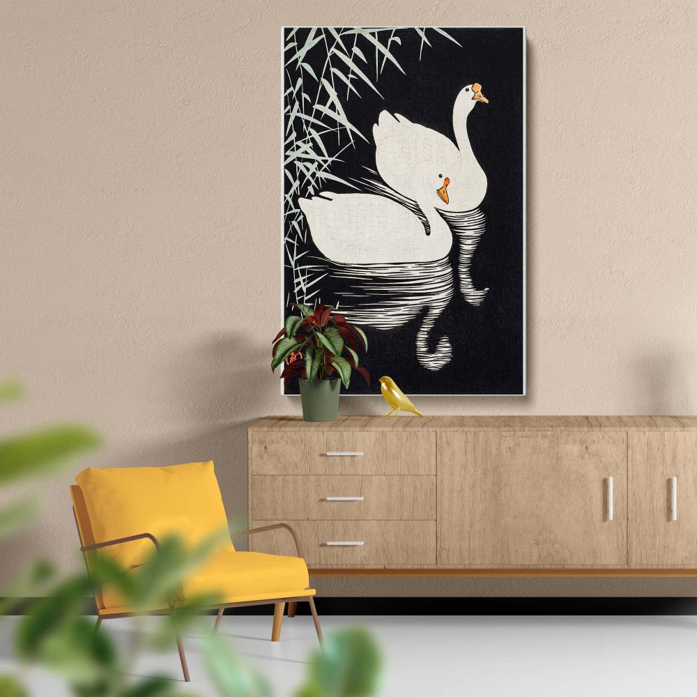 Traditional Japanese artwork by Ohara Koson from 1928 showcasing two white Chinese geese swimming peacefully near reeds, rendered in fine detail with a strong contrast between the light geese and the dark, minimalistic background.