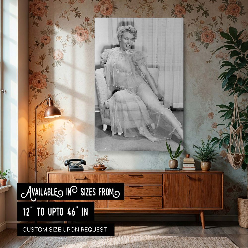 Marilyn Monroe canvas wall art featuring her seated in a classic armchair wearing a sheer embroidered gown captured in a vintage glamour photo print perfect for elegant woman decor and retro-inspired interiors celebrating timeless Hollywood beauty.