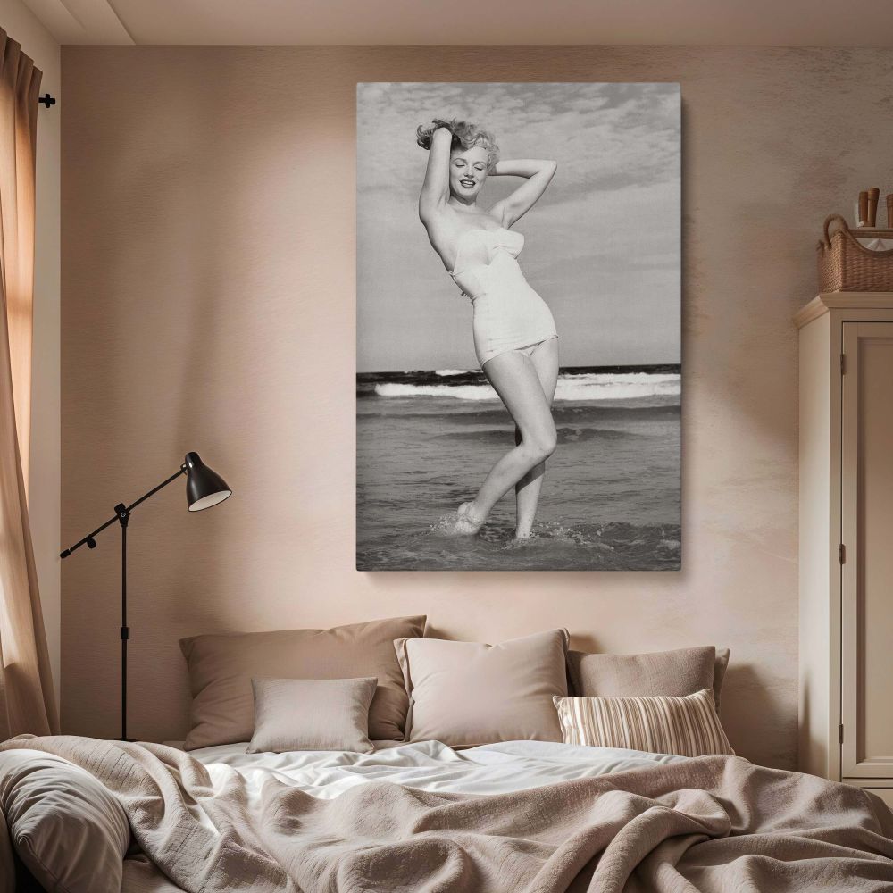 Iconic photo of Marilyn Monroe standing in shallow beach waves, smiling confidently in a classic swimsuit, captured on high-quality canvas wall art.