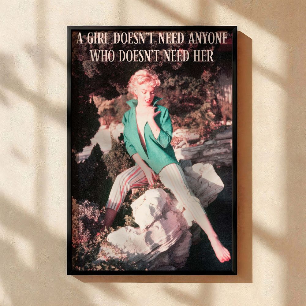 A candid moment featuring Marilyn Monroe in colorful striped trousers and open green blouse seated on rocks with bold empowering quote text overlay this vintage-style photo is perfect for feminine wall decor celebrating iconic woman strength and old Holly