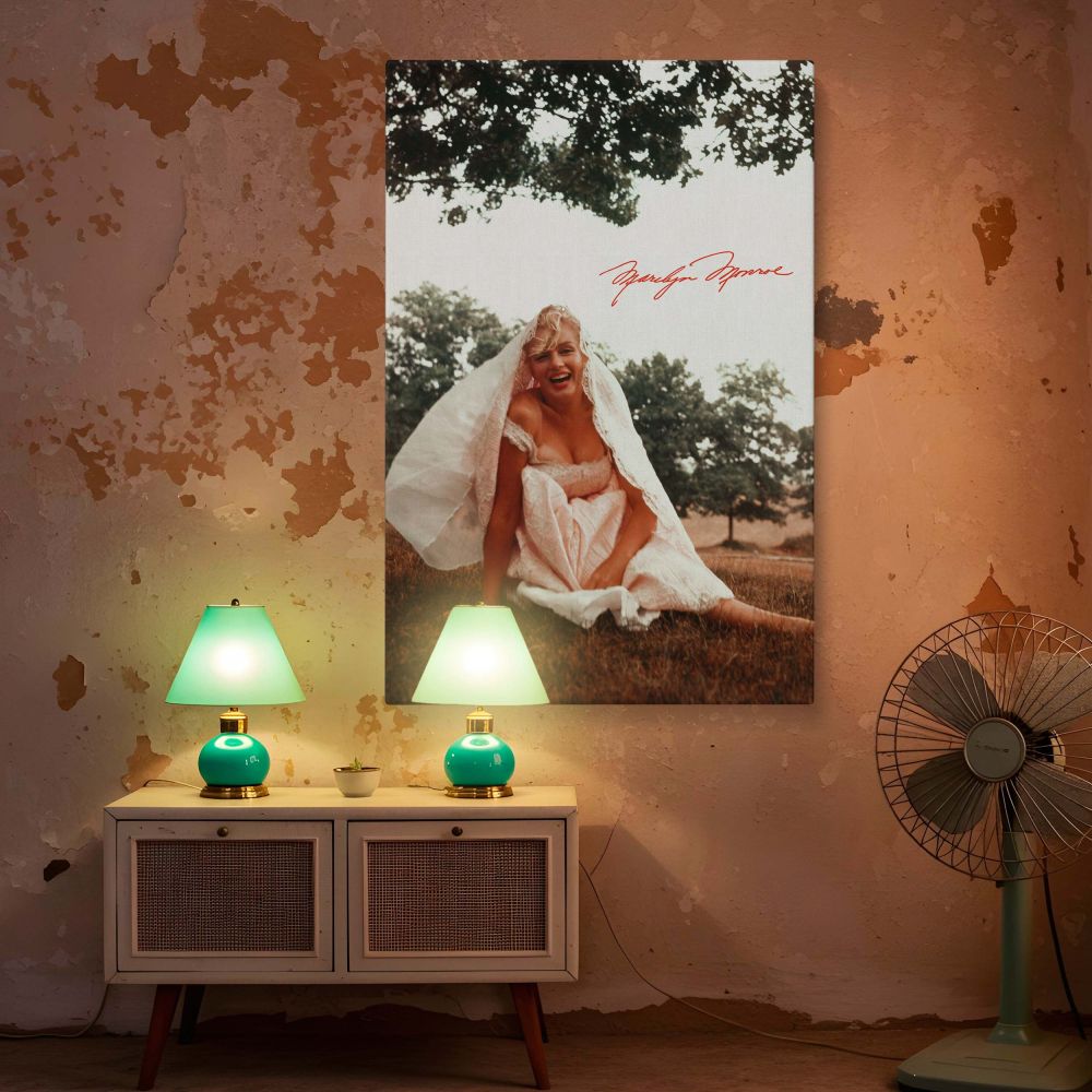 Vintage style Marilyn Monroe print showing her sitting on the ground in a white dress veil over her head smiling brightly a glamorous moment ideal for retro themed interiors vintage Hollywood lovers and photography enthusiasts seeking iconic prints.