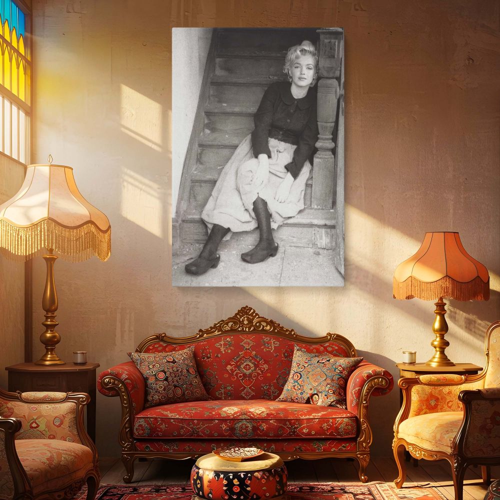 This evocative black and white photo shows Marilyn Monroe on stairs in a soft and natural pose wearing retro fashion her quiet confidence and Hollywood aura make this a beautiful piece of vintage wall decor and celebrity art.