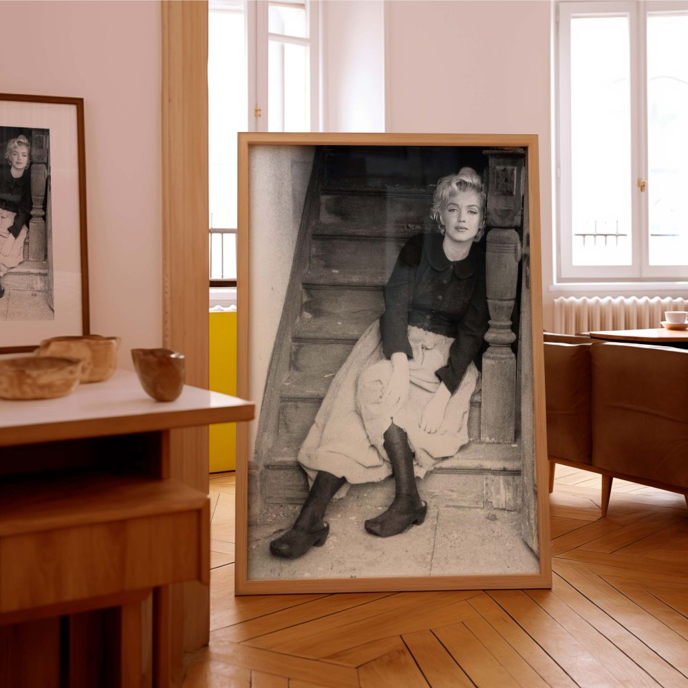 This vintage Marilyn Monroe portrait set on worn wooden steps features a soft but grounded aesthetic that reflects classic Hollywood glam in a down-to-earth setting a perfect art piece for retro decor and timeless beauty enthusiasts.