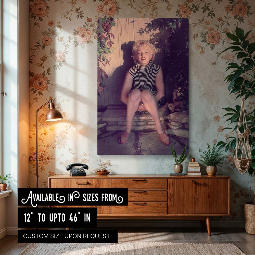 Marilyn Monroe sitting on a stone doorstep in a striped turtleneck dress with her knees tucked up and arms wrapped around her legs this vintage photo captures the essence of retro fashion wall art with its natural lighting and serene pose perfect for 1950