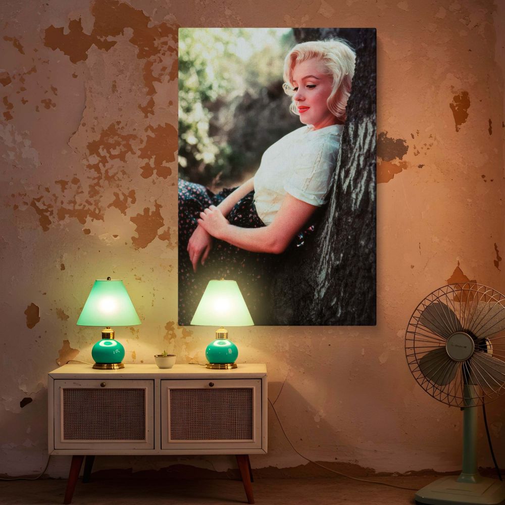 Featuring Marilyn Monroe in a relaxed pose beside a tree in nature this vintage wall art captures a softer side of the Hollywood legend in a timeless canvas print ideal for classic film photo collectors and those who cherish feminine beauty and grace from