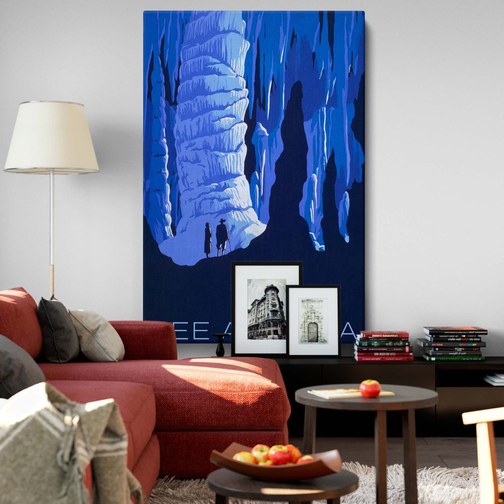 Wall canvas depicting two hikers standing inside a breathtaking ice cave with massive icy formations and deep blue tones, representing the majestic beauty and adventure of America's natural wonders in a serene and captivating scene.
