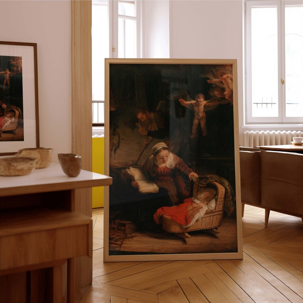 This canvas wall print shows The Holy Family by Rembrandt in a quiet, intimate setting as Mary lovingly watches over the sleeping Christ child. She holds a book while seated next to the cradle, and a soft glow lights her and the child. Cherubs float above