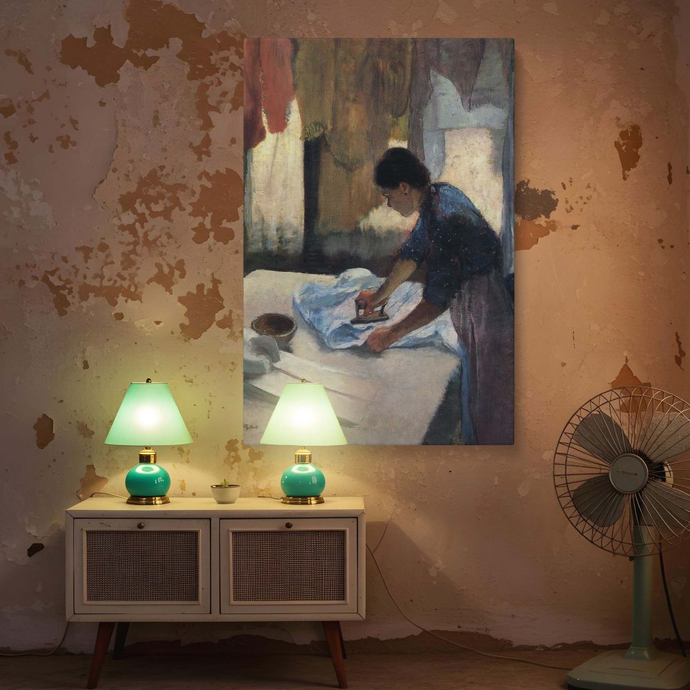 Degas's Woman Ironing printed on canvas, highlighting a domestic worker's strength and precision as she leans into the repetitive motion of ironing. The fabric folds, steam bowl, and ambient lighting provide a beautifully textured setting. This wall art p