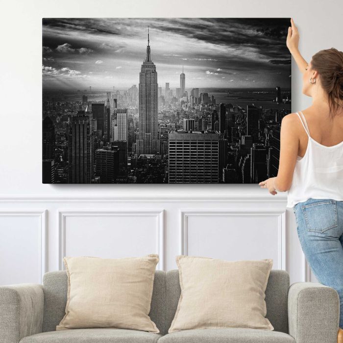 Black and white photo of the Empire State Building and downtown New York City canvas print, canvas shown with a person for scale