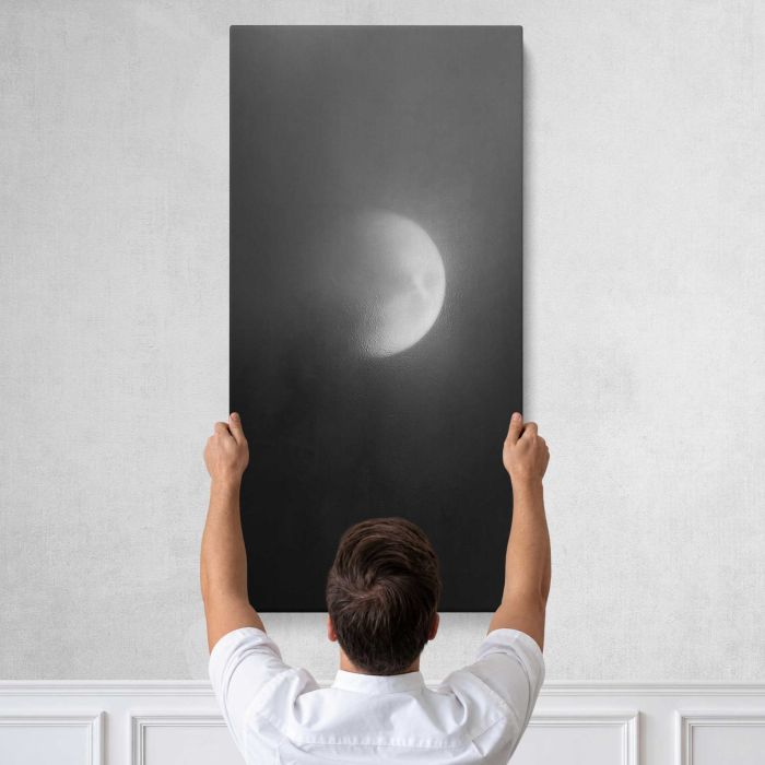 Ethereal moon shrouded in mist canvas print, tall canvas held against a wall