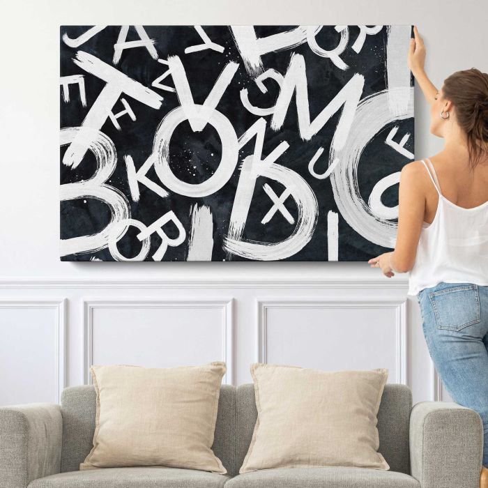 Mixed Letters in Black and White canvas print, canvas shown with a person for scale