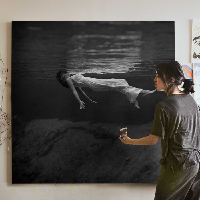Woman in a Long Gown Floating Underwater canvas print, canvas shown with a person for scale