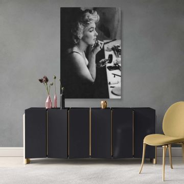 Timeless canvas print of Marilyn Monroe applying lipstick with soft lighting and vintage makeup tools present on the table perfect for fans of iconic black and white portraits and retro actress dressing room photo decor.
