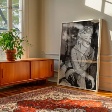 Graceful and warm black and white image of Marilyn Monroe in striped slacks seated casually and smiling in a cozy pose a must-have retro art piece that adds charm and character to classic Hollywood-themed interiors or vintage fashion photography walls.