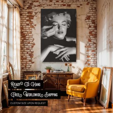 This striking Marilyn Monroe black and white print captures her getting makeup done with her hands softly crossed and eyes closed symbolizing classic Hollywood preparation and poise a perfect photo wall art for beauty spaces and vintage film-themed interi