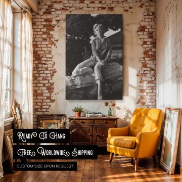 Classic black and white photo print of Marilyn Monroe sitting outdoors against a natural backdrop wearing striped capri pants and a casual blouse evoking timeless style and vintage Hollywood charm ideal for bedroom or gallery wall art decor celebrating fe