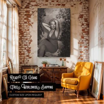 This black and white Marilyn Monroe wall art shows her seated in a red jumpsuit with foliage around her perfect for vintage fashion fans iconic actress enthusiasts and retro decor collectors who adore timeless Hollywood glamour.