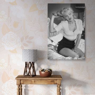 Marilyn Monroe canvas print of the iconic actress brushing her hair on a bed captured in black and white ideal canvas wall art for home decor.