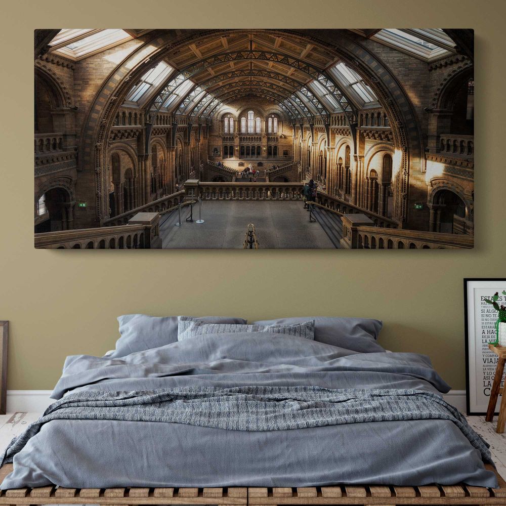 Sunlit Hall at the Natural History Museum — single-panel canvas above a bed with blue bedding