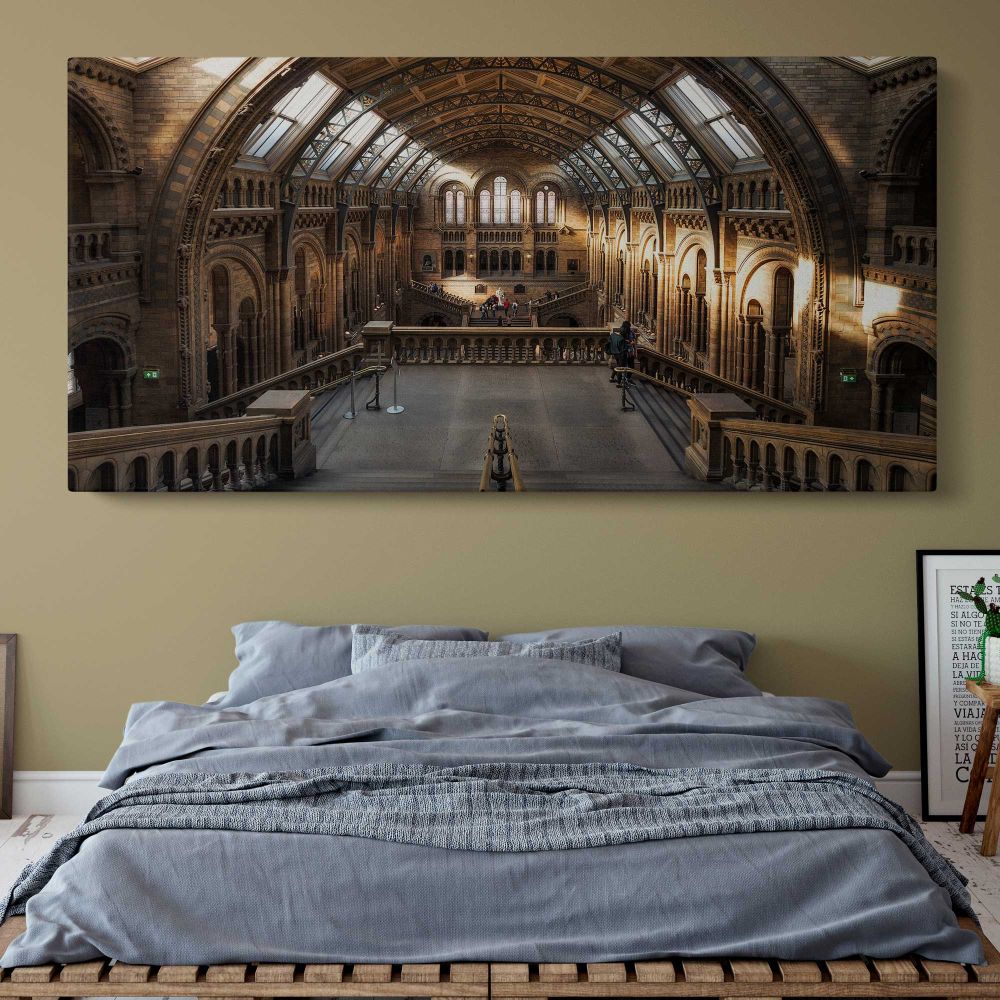 Sunlit Hall at the Natural History Museum — single-panel canvas above a bed with blue bedding