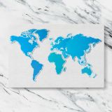 Blue World Map on White canvas artwork displayed on a marble background