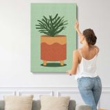 Leafy Plant in a Terracotta Pot canvas print, displayed on a wall