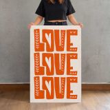 Love Love Love Orange Typography canvas print, held for scale