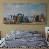 The Beach at Trouville by Claude Monet — single-panel canvas above a bed with blue bedding